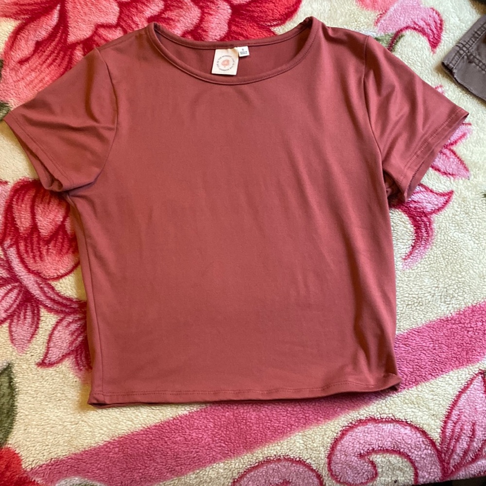 A dark pink cropped shirt